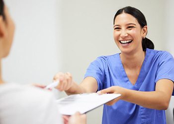 Dentist handing a patient dental insurance info