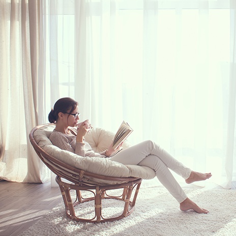 Woman relaxing at home in comfy chair