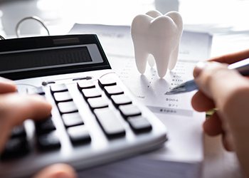 Person using calculator to budget for dental care